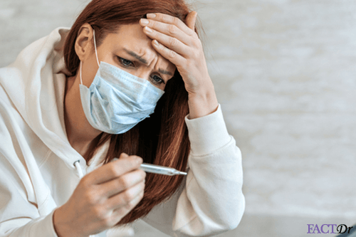 Woman with covid-19 mask checking temperature fever